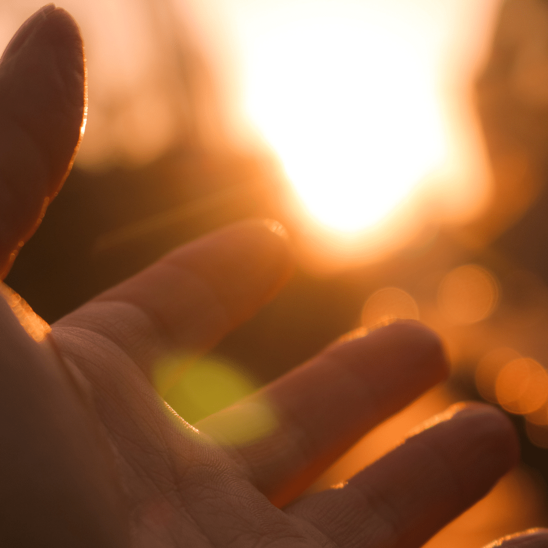 A human hand reaching towards sunlight, symbolizing hope and recovery from substance use disorders.
